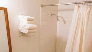 Ein Badezimmer mit Toilette, Waschbecken, Dusche und Handtuchhalter.