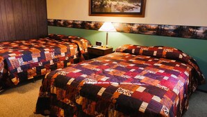 Ein Hotelzimmer mit zwei Betten, einem Nachttisch, einer Lampe und einem Bild an der Wand.