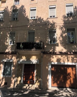 Ein mehrstöckiges Gebäude mit Balkonen, einem verschlossenen Eingang und einer sichtbaren Garagentür.
