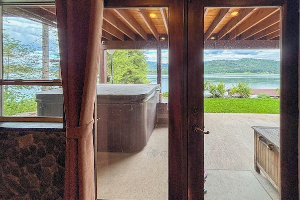 A wooden door leading to a room with a view of a lake and mountains. - Waterfront Gem on the River! Hot Tub & Boat Dock! (Priest River)