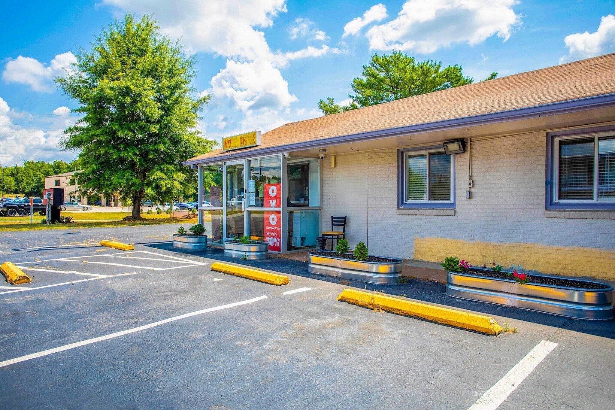 A building with a storefront, parking lot, and outdoor seating area.