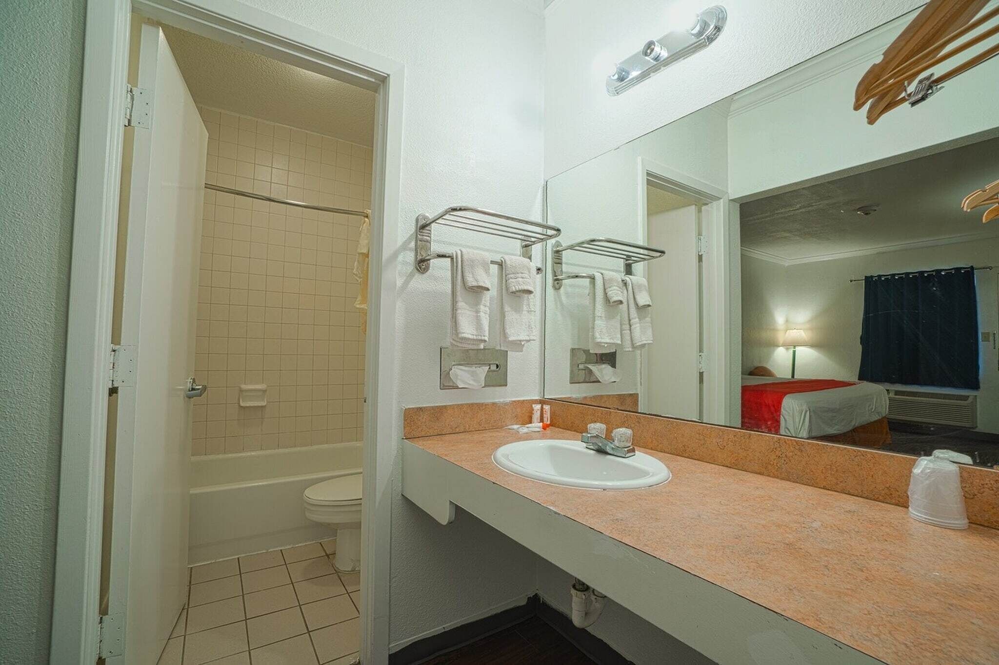 Une salle de bain équipée d’un lavabo, d’un miroir, d’un porte-serviettes et d’un espace douche.
