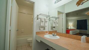 Une salle de bain équipée d’un lavabo, d’un miroir, d’un porte-serviettes et d’un espace douche.