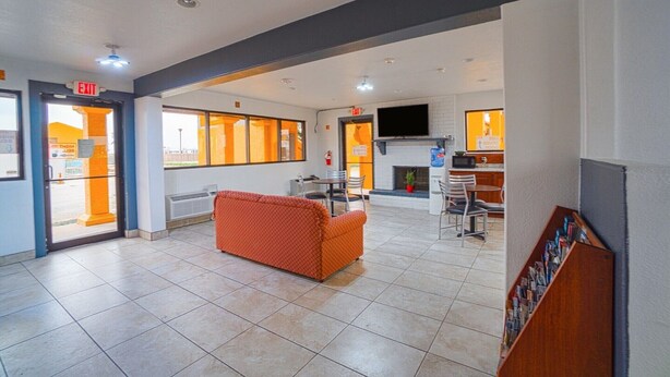 A lobby with a sofa, a fireplace, a television, and a magazine rack. - Kingsville | King Bed (Kingsville)
