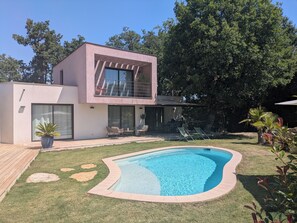 A modern two-story house with a swimming pool, outdoor seating, and a large tree in the background. - Contemporary home with a pool, in a quiet location. The village of Mouans Sartoux is 5 minutes away. (Mouans-Sartoux)