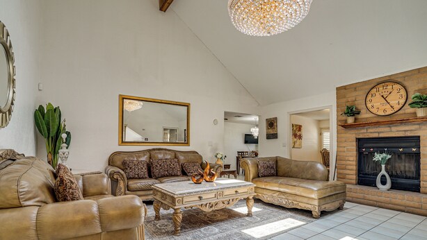 Una sala de estar con chimenea, un espejo grande y una araña.