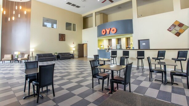 A hotel lobby with a checkered floor, a reception desk, and seating areas.