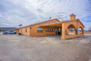 A building with a covered entrance, satellite dishes, and a truck parked outside.