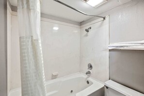 Une salle de bain avec une baignoire, une douche et un porte-serviettes.