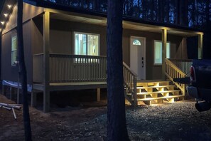 A cabin with a front porch, a staircase, and a vehicle parked outside. - Woodsy Cabot Escape in Arkansas Countryside! (Cabot)