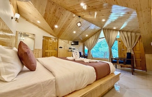 A wooden-paneled room with a bed, a TV, and a view of the outdoors.
