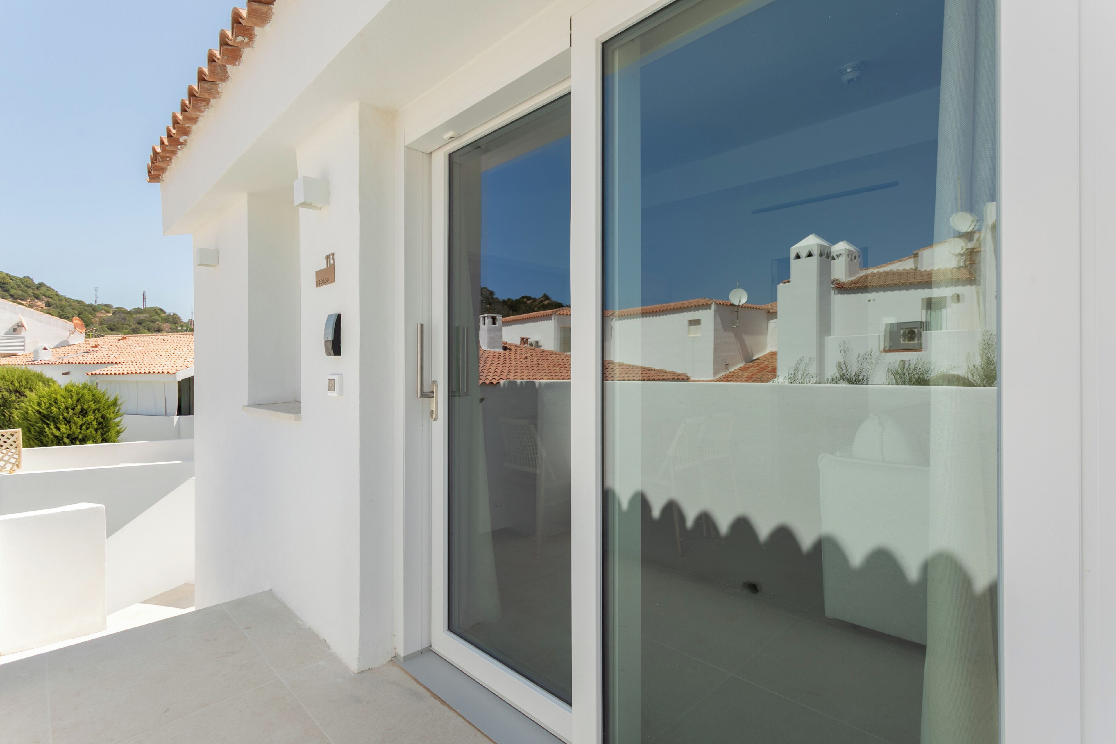A modern building with a glass door leading to a balcony.