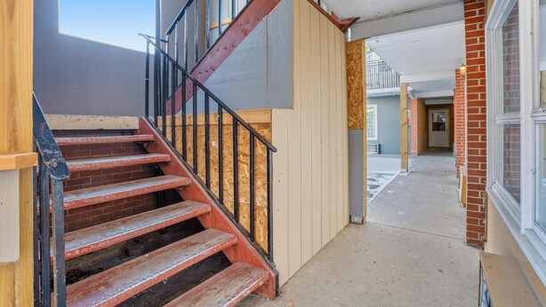 A staircase with wooden steps and metal railings leading to a second floor. - 2 Queen Beds|Non-Smoking (Devils Lake, ND)