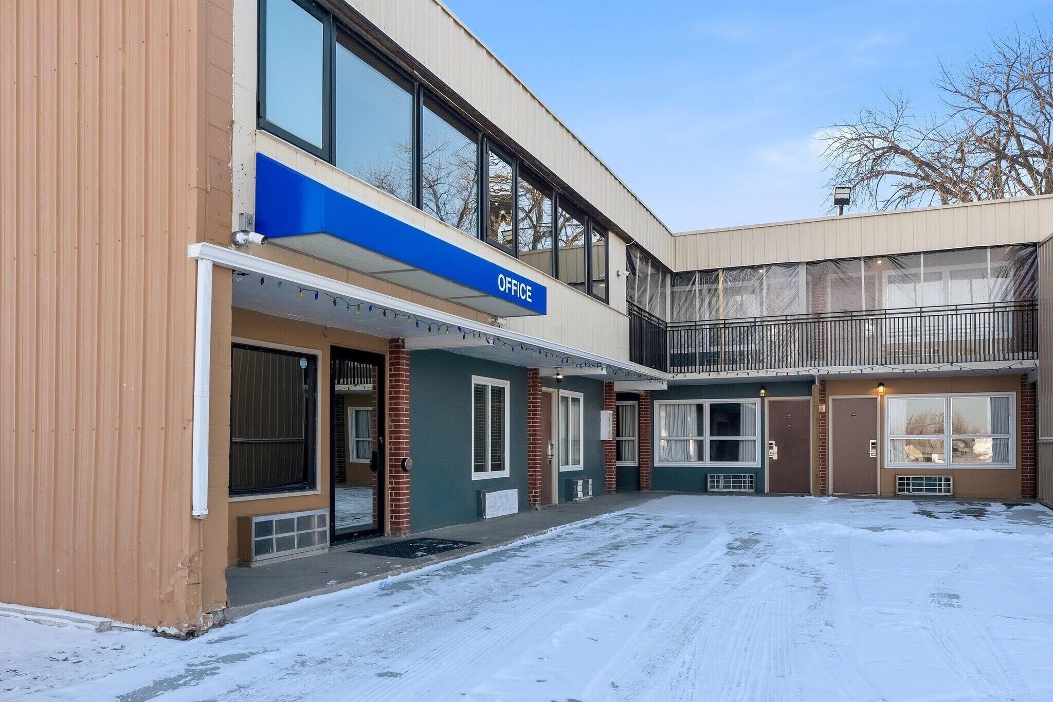 A building with an 'OFFICE' sign, a covered entrance, and a snow-covered ground.