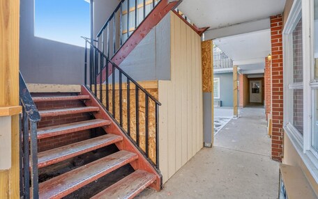 A staircase with wooden steps and metal railings leading to a second floor.