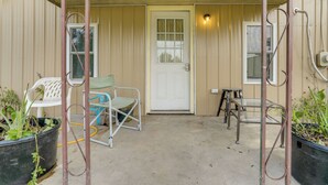 A porch with a door, two chairs, and potted plants. - Home Near Eleven Point River & Nat'l Forest! (Alton)