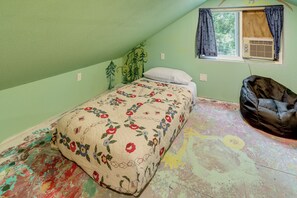A bedroom with a bed, a window with curtains, a radiator, and a bean bag chair. - Home Near Eleven Point River & Nat'l Forest! (Alton)
