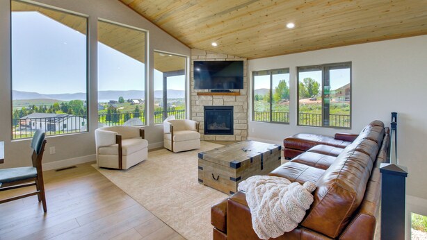 Un salón amplio con chimenea, ventanas grandes y vistas al exterior.