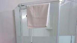 Eine Duschkabine mit Glastüren und ein Handtuch am Türgriff.