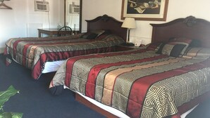 Ein Hotelzimmer mit zwei Betten, einem Schreibtisch und einem Stuhl.