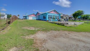 Un quartier résidentiel avec des maisons, une cour clôturée et un ciel dégagé.