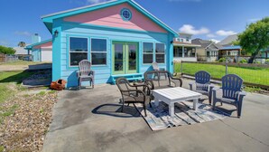 Une maison dotée d’un patio aménagé avec du mobilier d’extérieur et offrant une vue dégagée sur le quartier.