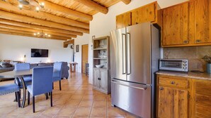Eine moderne Küche mit Holzschränken, einem Edelstahlkühlschrank und einem eingebauten Backofen.