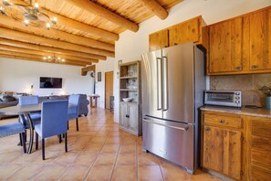 Eine moderne Küche mit Holzschränken, einem Edelstahlkühlschrank und einem eingebauten Backofen.