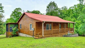 A wooden cabin with a red roof, a porch, and a small deck. - Steps to Nolin Lake! Retreat 11 Mi to Mammoth Cave (Cub Run)