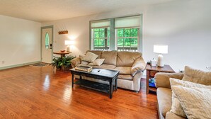 A living room with a beige sofa, a coffee table, and two windows with blinds. - Steps to Nolin Lake! Retreat 11 Mi to Mammoth Cave (Cub Run)