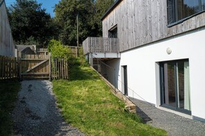 Ein modernes Gebäude mit Holzfassade, Kiesweg und Holzzaun.