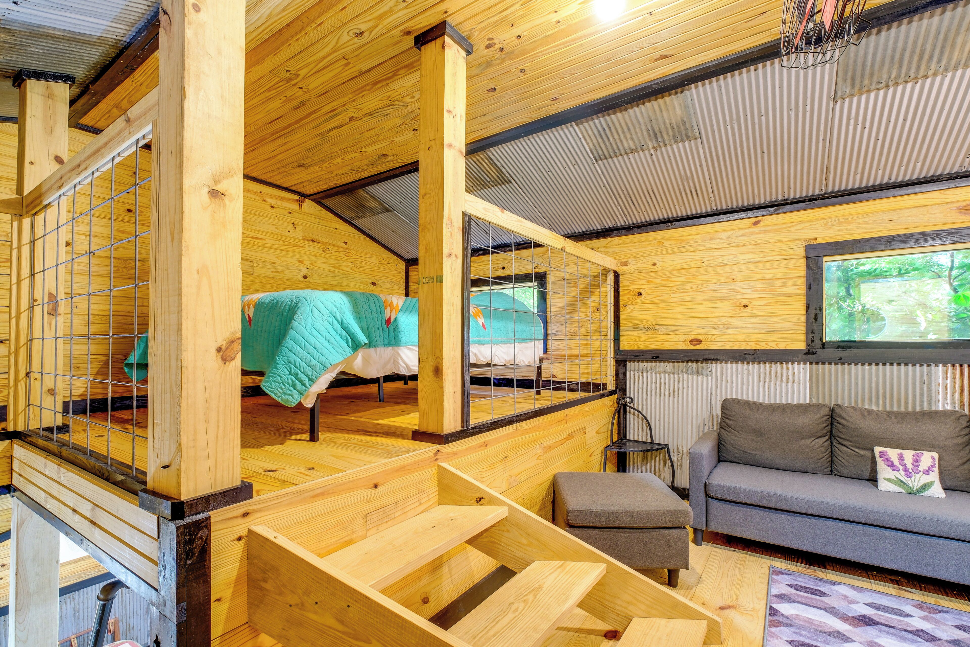 Un intérieur en bois avec un escalier, un canapé et une fenêtre.