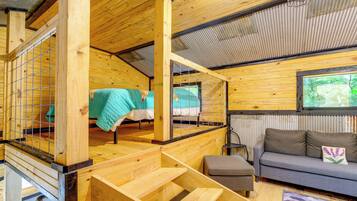 Un intérieur en bois avec un escalier, un canapé et une fenêtre.