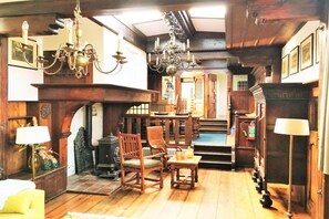 A traditional room with wooden furniture, a fireplace, and a chandelier.