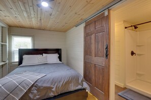 Ein Schlafzimmer mit einem Bett, einer Holztür und einem Fenster.