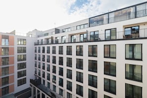 Ein mehrstöckiges Gebäude mit Balkonen, großen Fenstern und einer glatten Fassade.