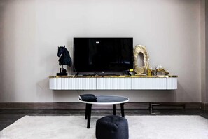A modern living room with a flat-screen TV, a round coffee table, and a sofa. - Facai Star Villa A22 (Banglamung)