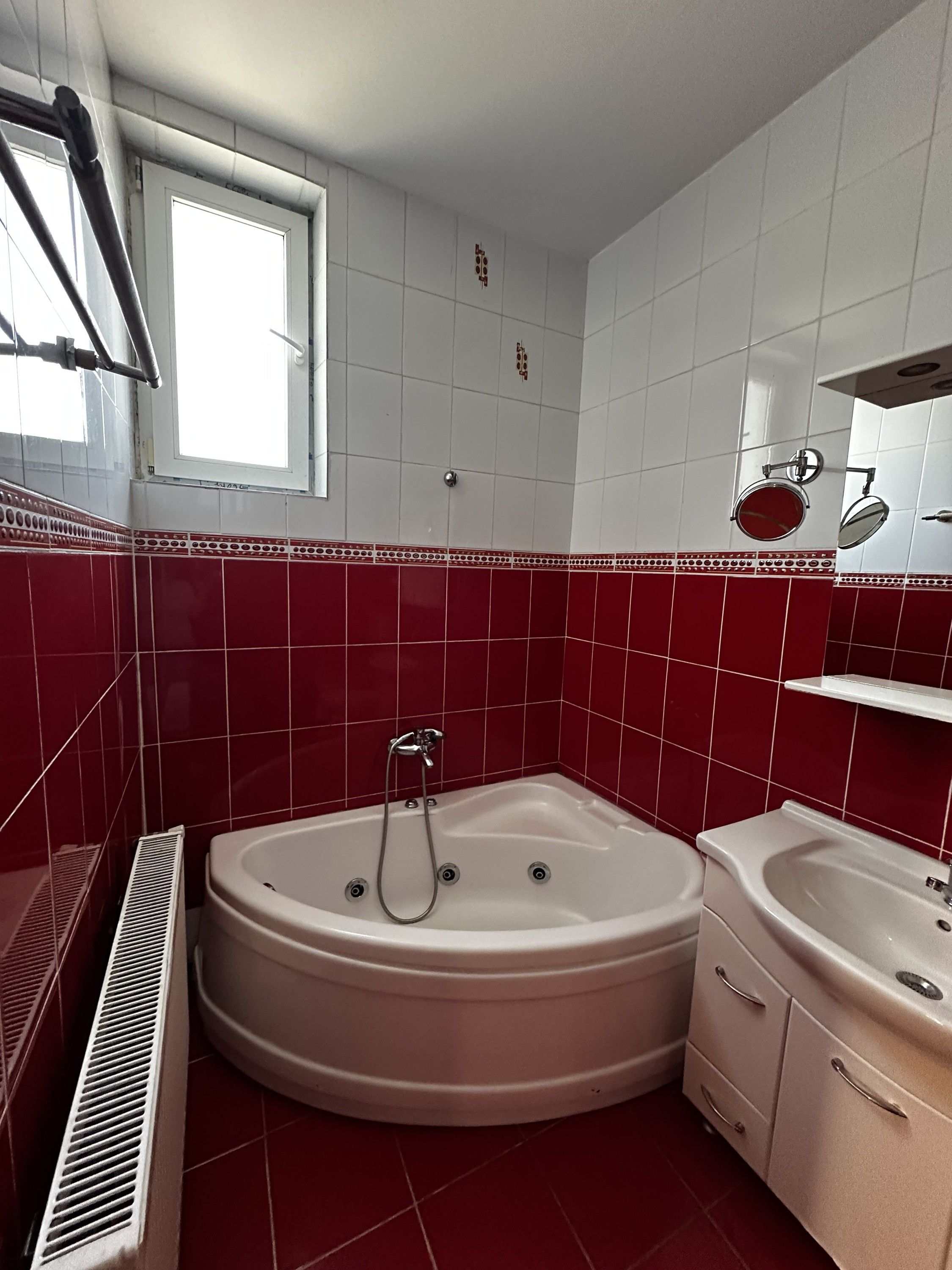 Ein Badezimmer mit Badewanne, Waschbecken, Fenster und Dusche.