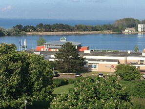 Un bâtiment doté d’un toit plat, d’un espace de stationnement et offrant une vue sur une étendue d’eau.