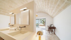 A modern bathroom with a large sink, mirror, and a lamp. - Trulli Vigna Lamafico Suites & Pool (Polignano a Mare)