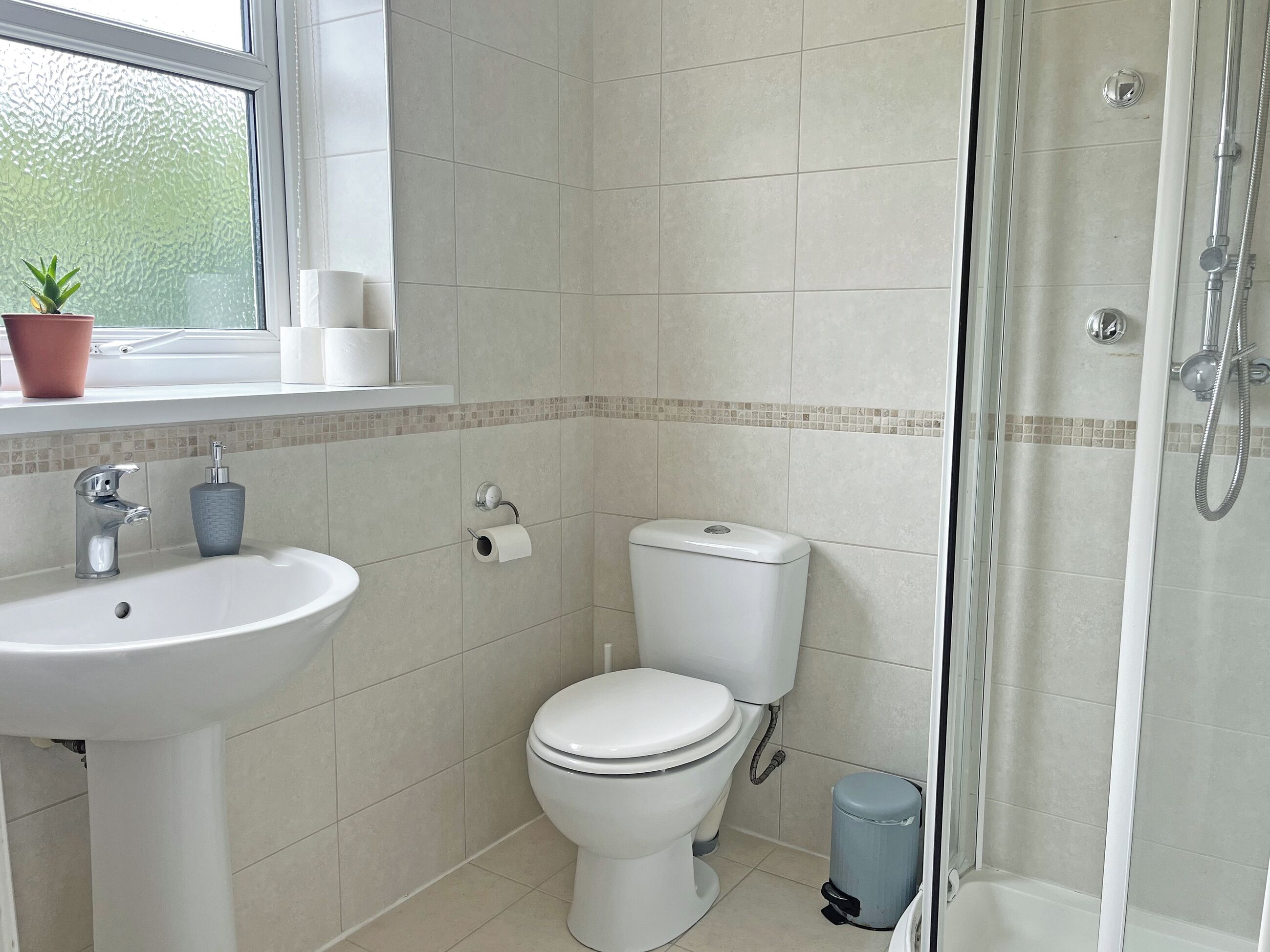 A bathroom with a sink, toilet, and shower.