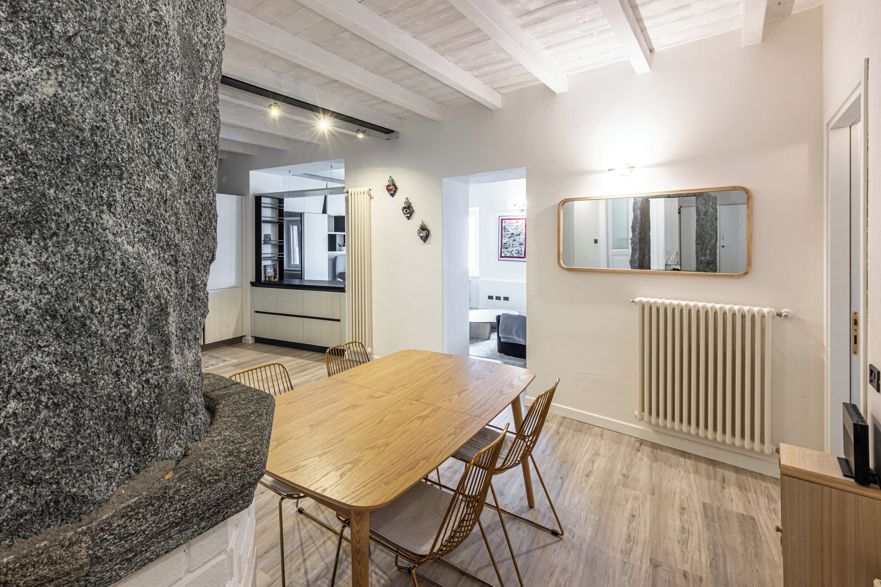 Una cocina moderna con una isla de granito, una mesa de comedor de madera y sillas.