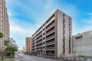 Un aparcamiento de varios pisos con diseño moderno, que presenta una serie de balcones y un techo plano.