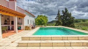 A swimming pool with steps leading up to it, a covered patio area, and a view of the surrounding landscape. - Quinta do Espinhal, Countryside Retreat Pool (Santarém)