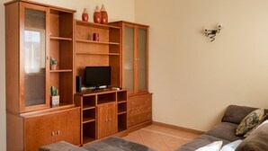 A living room with a wooden cabinet, a television, and a sofa. - Central Albufeira Stay Balcony AC (Albufeira)