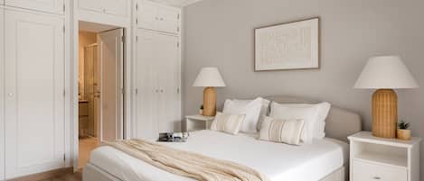 A bedroom with a bed, nightstands, a lamp, a wardrobe, and a framed picture on the wall.