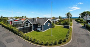 A residential area with houses, a well-maintained lawn, and a clear sky. - Bright holiday home with large terrace near Nyborg (Nyborg)