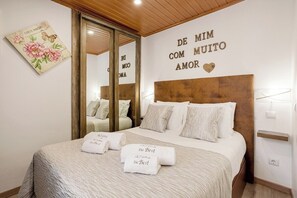 A hotel room with a bed, a mirror, a wall with a message, and a floral artwork. - Alfama The Best II, in Old Lisbon (Lisbon)