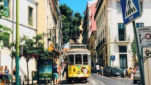 A yellow tram on a city street with buildings on either side. - Alfama The Best II, in Old Lisbon (Lisbon)