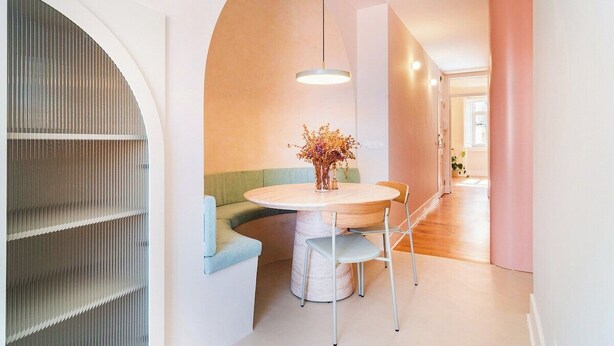 A modern interior with a round table, a green sofa, and a large arched window. - Lisbon Design Apartment Workspace AC (Lisbon)